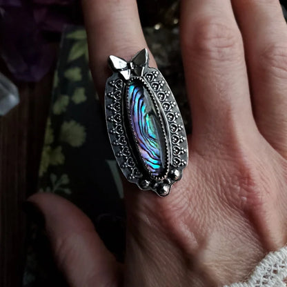 someone is holding a ring with a cat’s paw on it