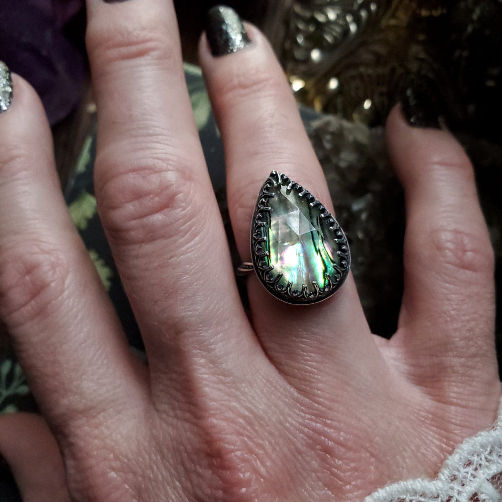 a woman’s hand with a ring on it