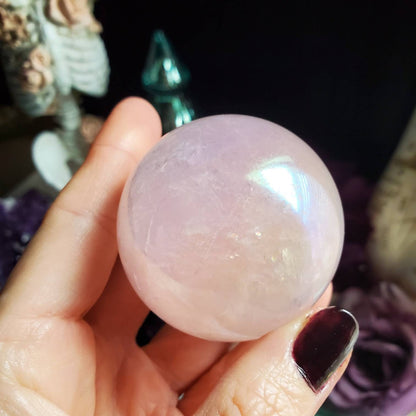 a person holding a pink quartz ball
