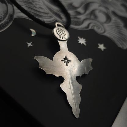 Silver bat-winged cross pendant.