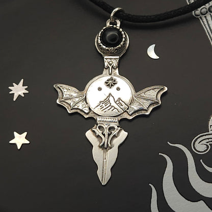 Silver bat-winged pendant with black stone.