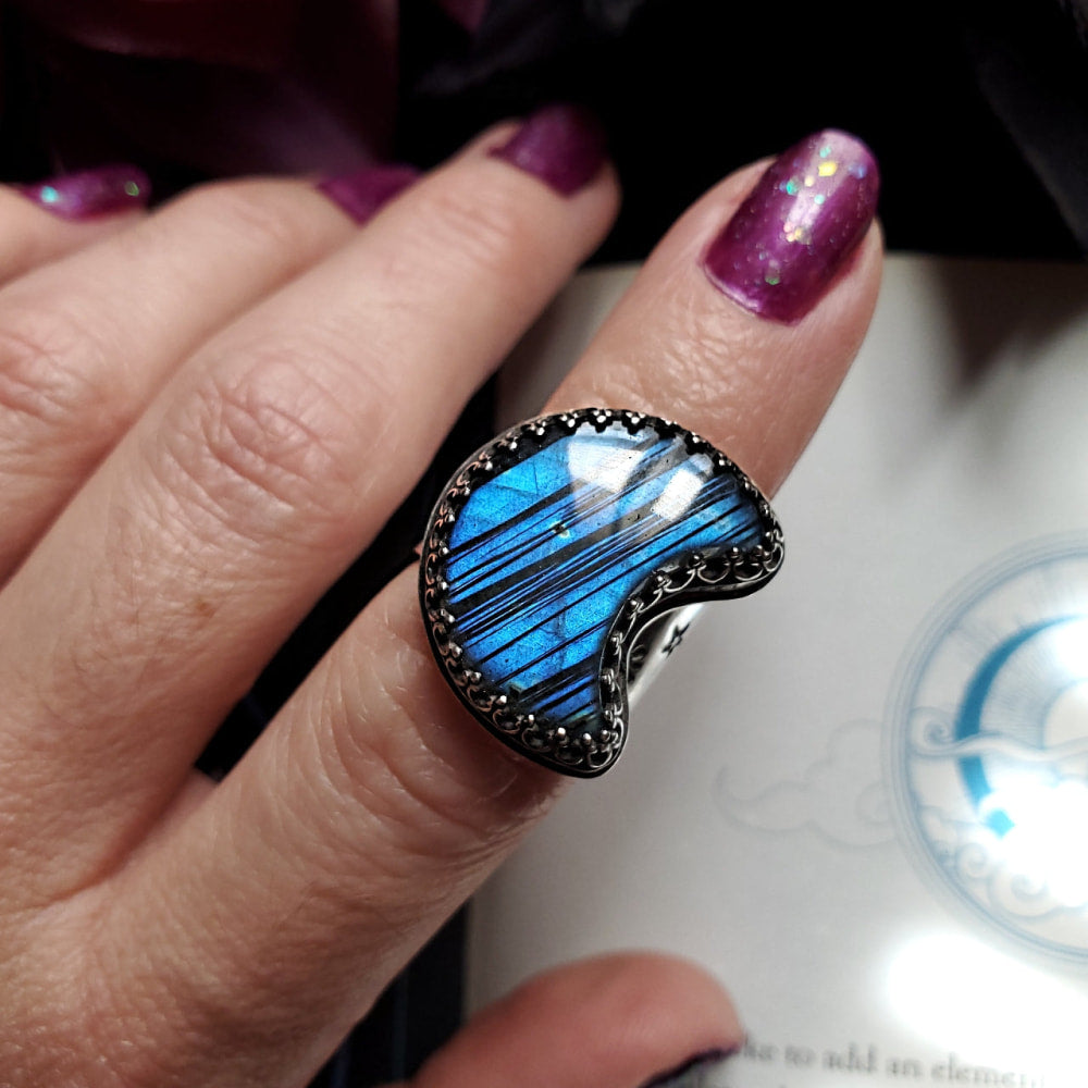 a woman’s hand holding a blue ring