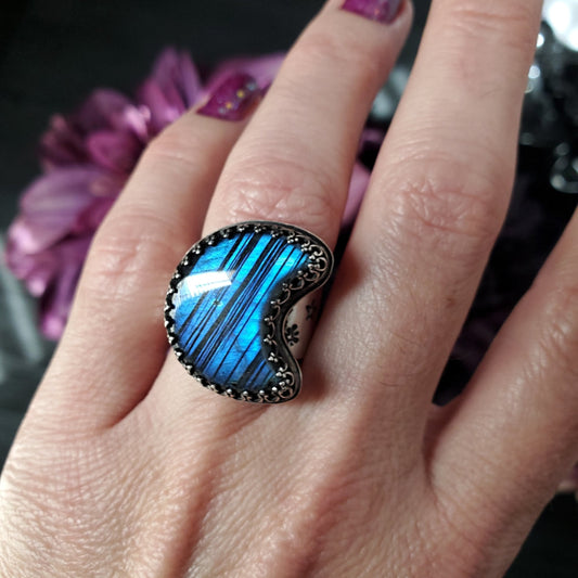 a woman’s hand with a blue ring on it
