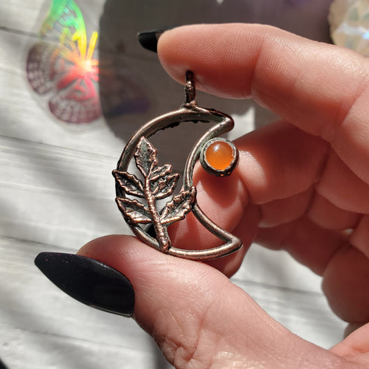 a person holding a ring with a leaf on it