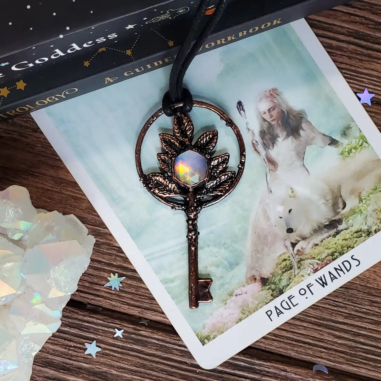 An ornate, leaf-designed key pendant with an iridescent gemstone center.