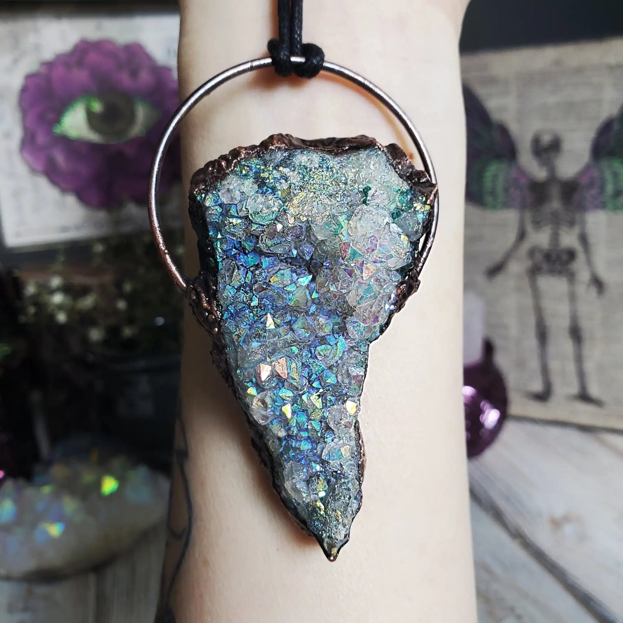 A raw, iridescent aura quartz crystal pendant set in copper.