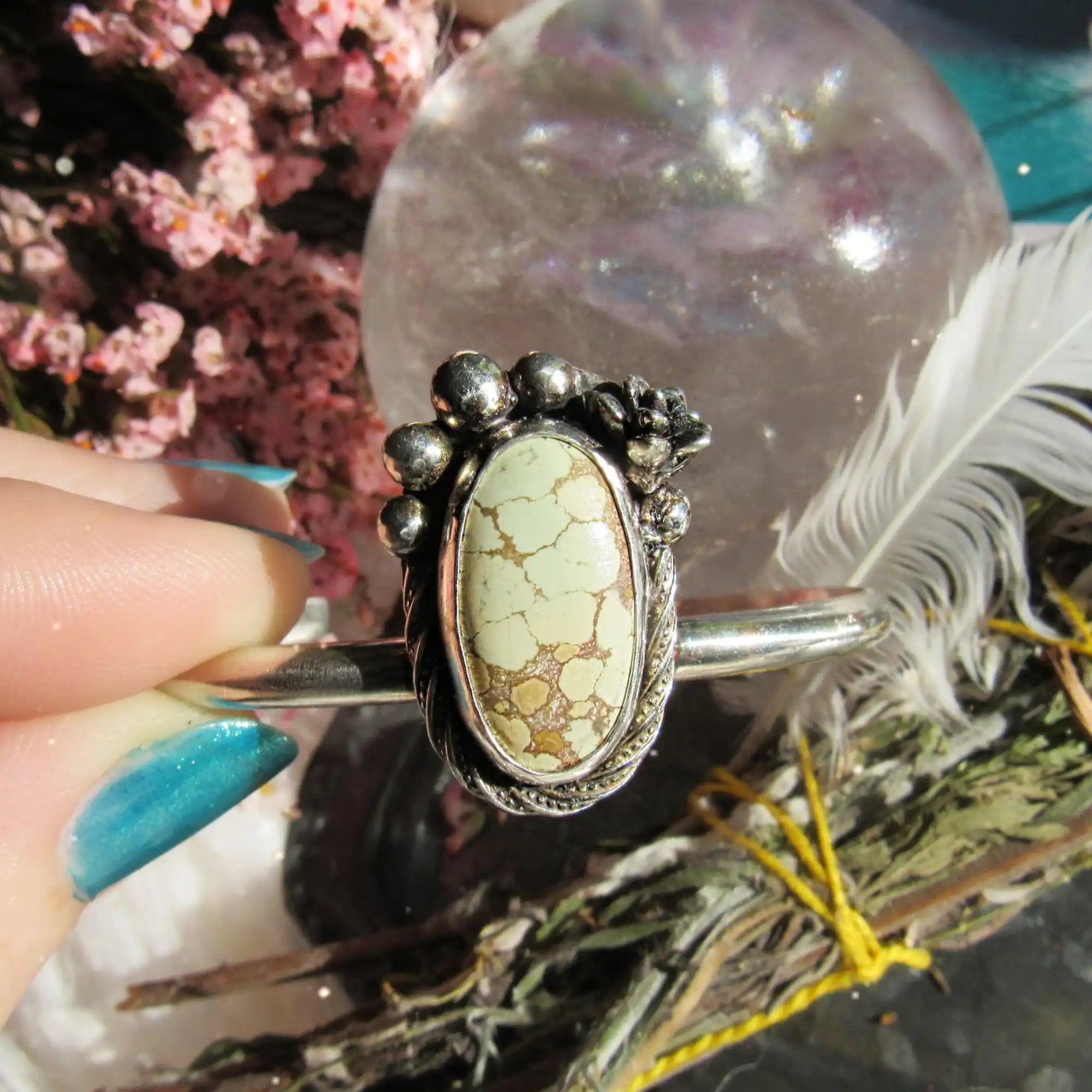 A silver ring with an oval, light green and brown mottled stone.