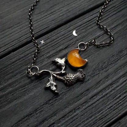a necklace with a small orange stone on it