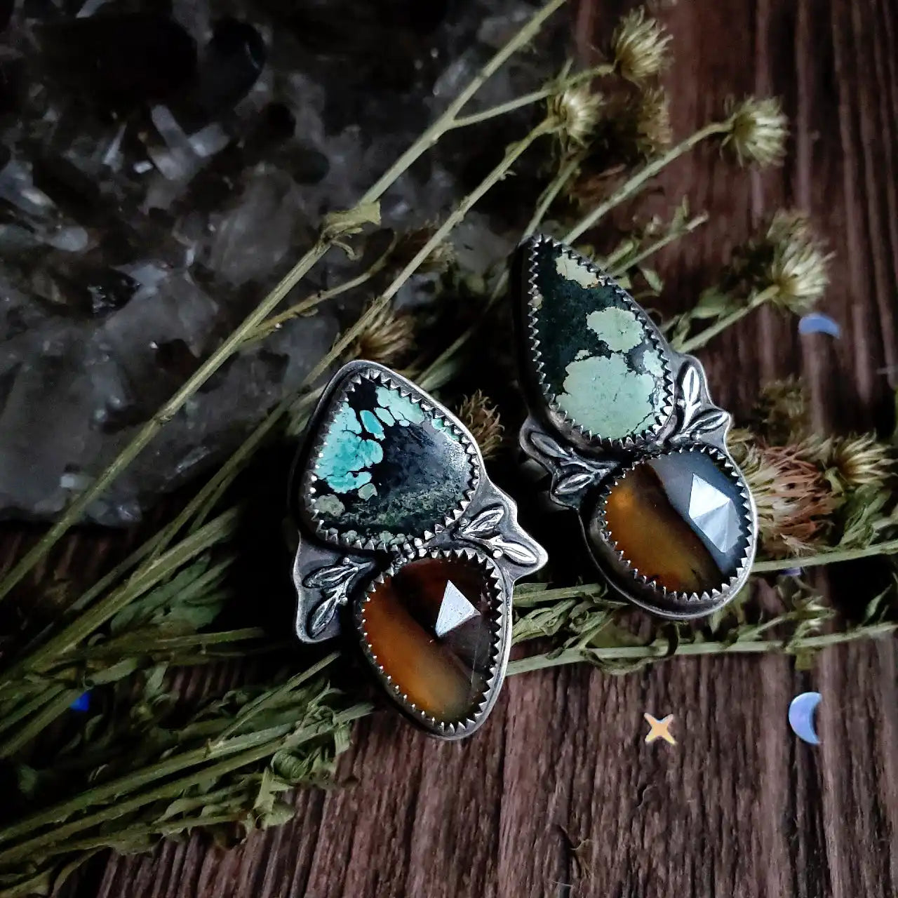 Two ornate silver rings with turquoise and tiger’s eye gemstones.